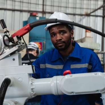 Industrial engineers are controlling the automated robot arms machine welding steel welding robots in industrial manufacturing factory.